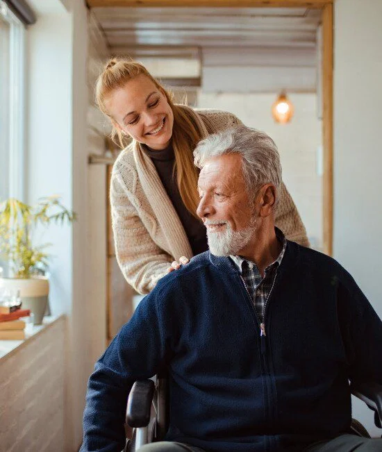 woman pushing man in wheelchair