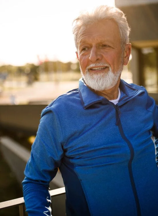 Portrait of a senior man looking away. He is relaxing after work out.