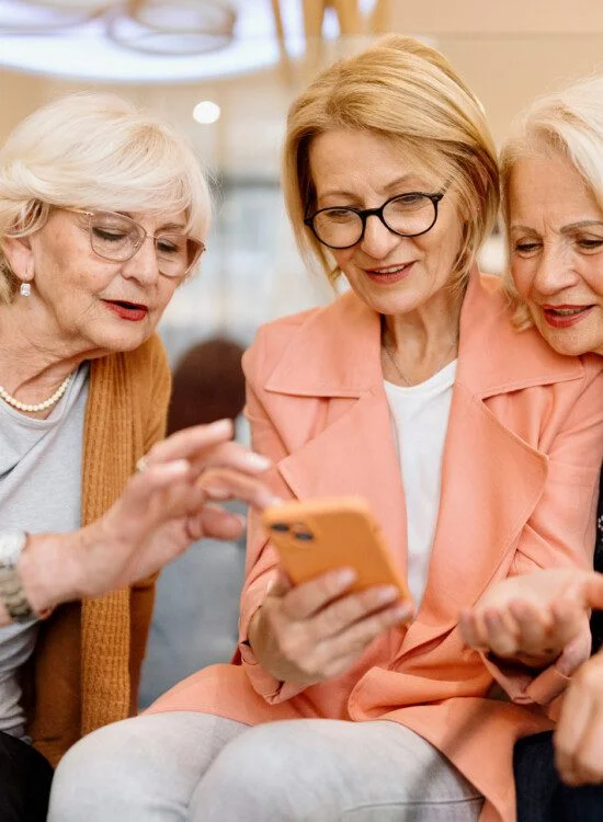 Three senior female friends enjoying vacation time in hotel cafe