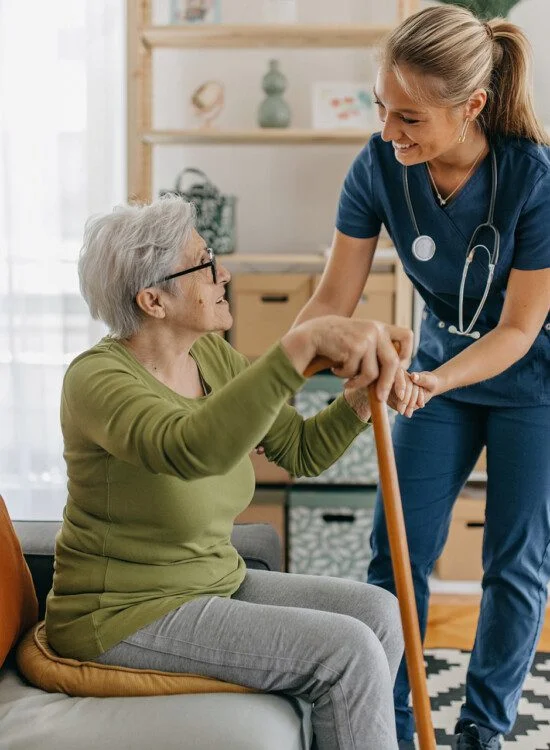 Senior woman being helped to stand up.