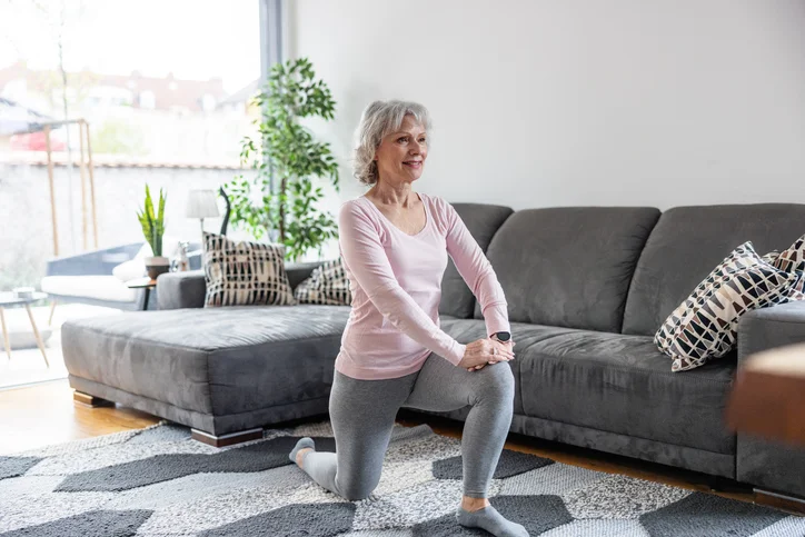 Senior Caucasian Woman Doing Lunge Stretch Exercise At Home