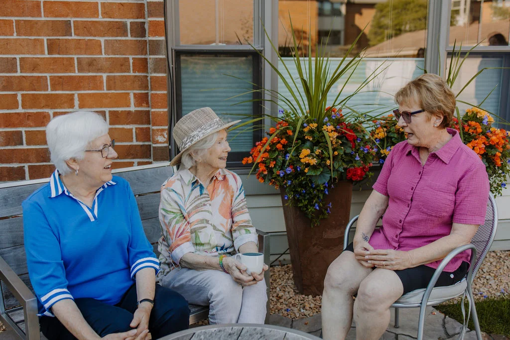 Residents chatting on the patio at Friendship Village of Bloomington, Minnesota