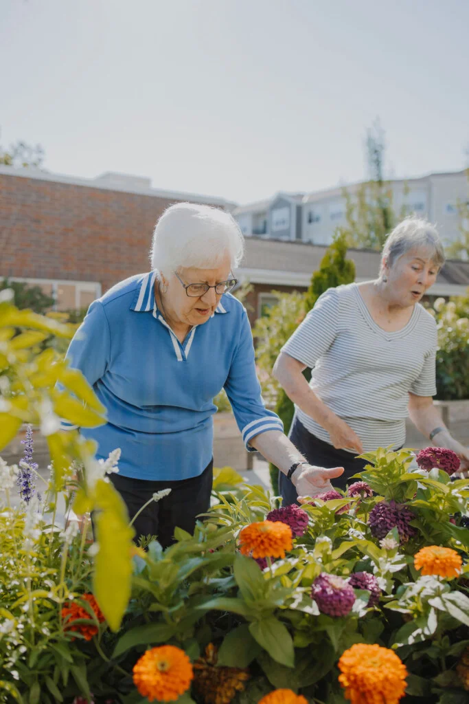 Resident volunteers talking beside a garden bed at Friendship Village of Bloomington, Minnesota