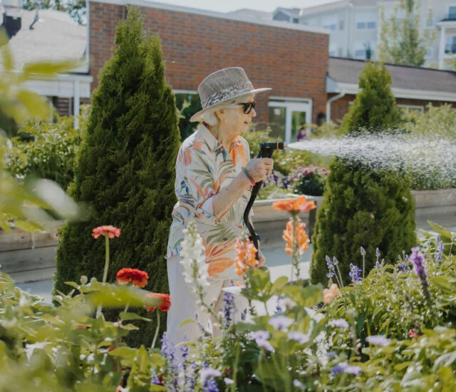Resident volunteers watering flowers at Friendship Village of Bloomington, Minnesota