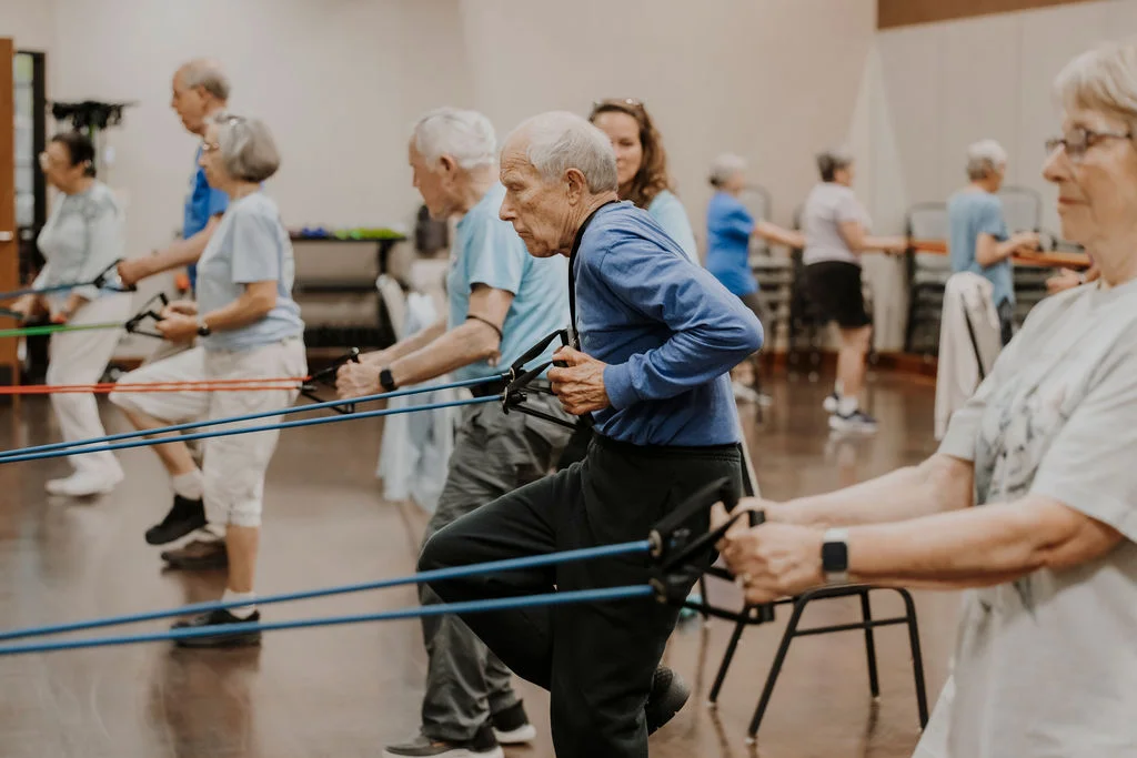 Residents using resistance bands during a group fitness class at Friendship Village of Bloomington
