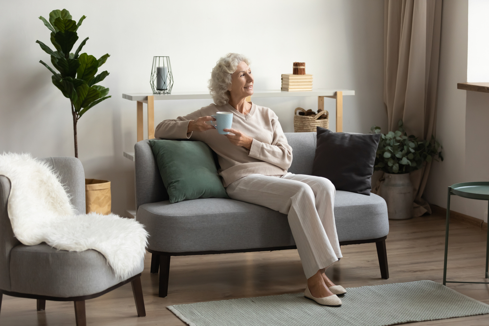 Senior woman sitting enjoying coffee in her apartment
