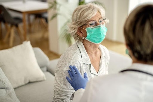 healthcare worker puts her hand on a senior citizen resident's shoulder