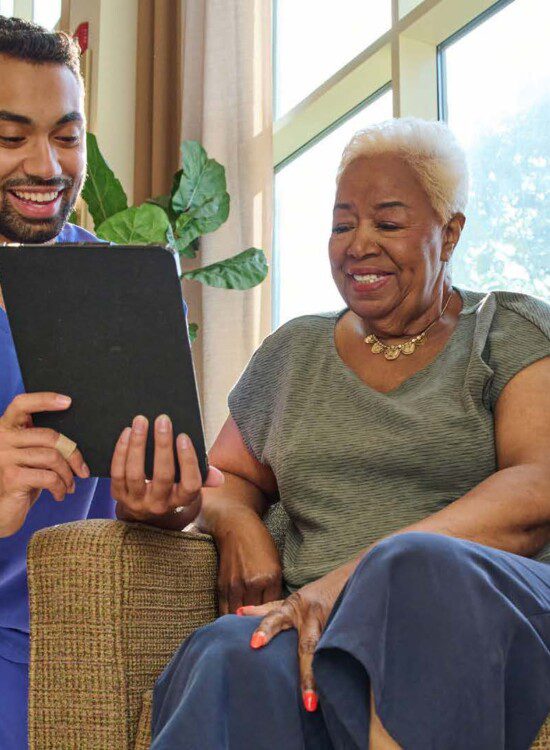young man showing tablet to older woman