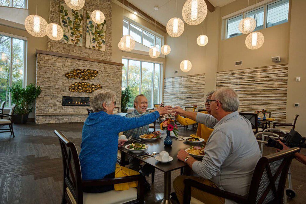 seniors at dinner table toasting with wine glasses