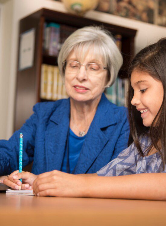 grandmother and granddaughter writing