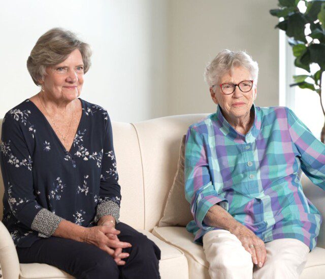 Two women sitting on sofa