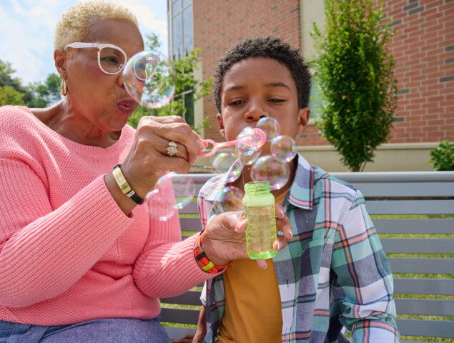 grandmother and grandson blowing bubbles