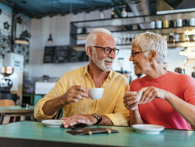 two seniors sharing a cup of coffee and conversation