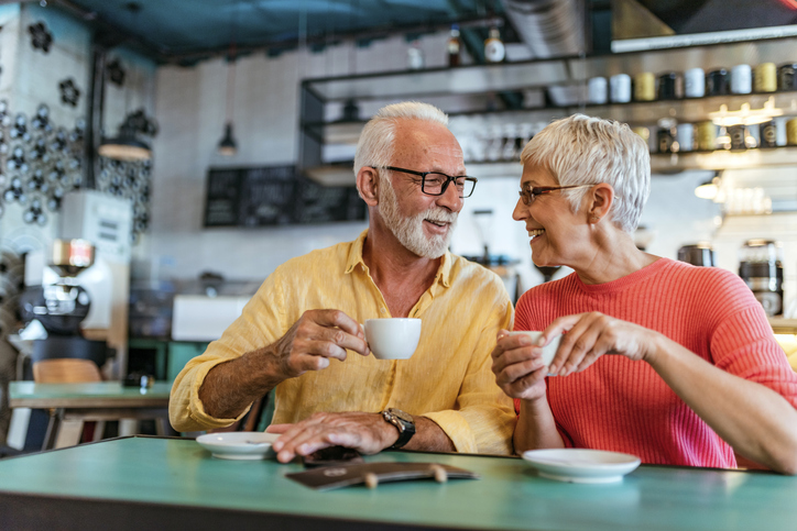 two seniors sharing a cup of coffee and conversation