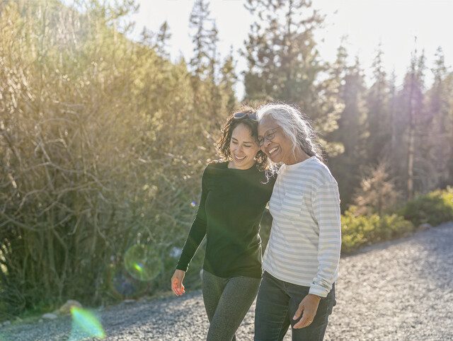 Senior friends walk along a path while laughing