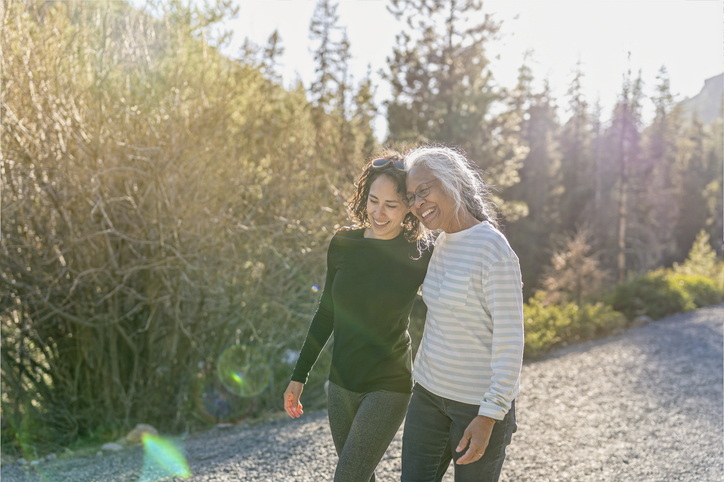 Senior friends walk along a path while laughing