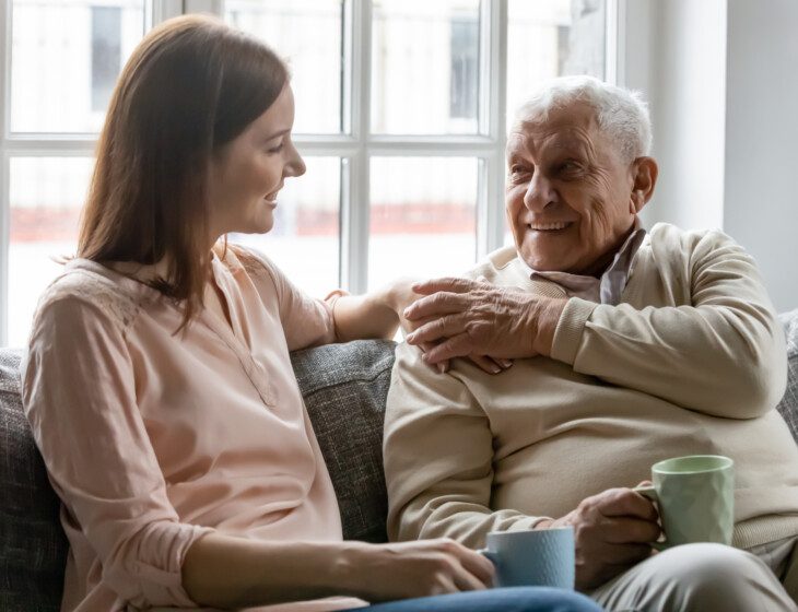 adult woman talks with her happy older father
